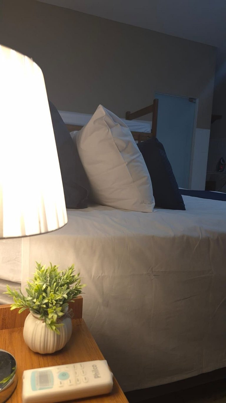 Quarto | Suíte com Ar | Mesa para refeições e frigobar.