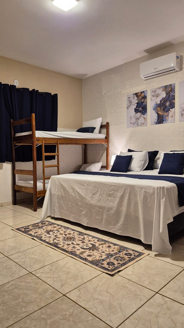 Quarto | Suíte com Ar | Mesa para refeições e frigobar.