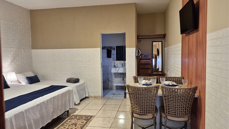 Suite com café da manhã, mesa para refeições e frigobar.