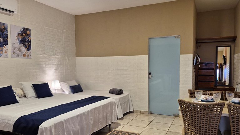 Suite com café da manhã, mesa para refeições e frigobar.