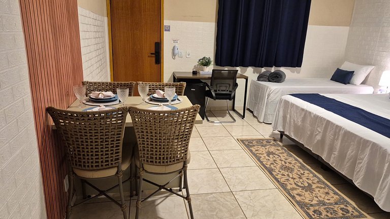 Suite com café da manhã, mesa para refeições e frigobar.